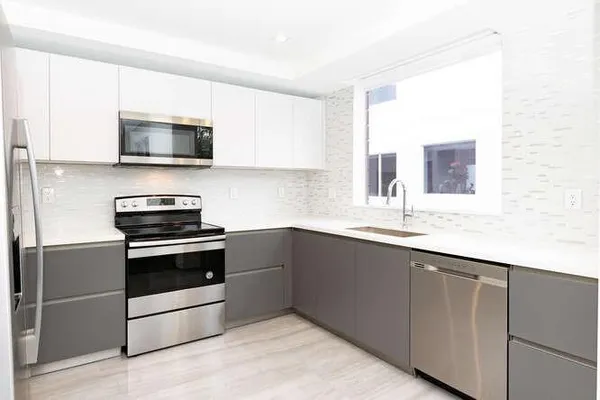 a kitchen with stainless steel appliances a refrigerator and a window