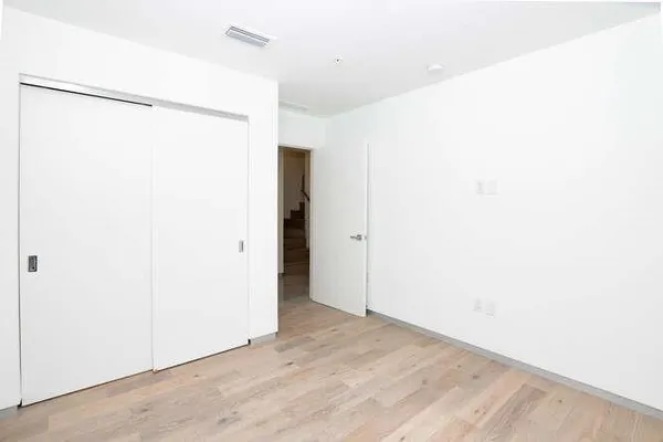 a bedroom with a bed and wooden floor