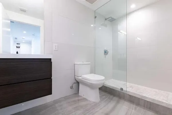 a bathroom with a sink a toilet and shower