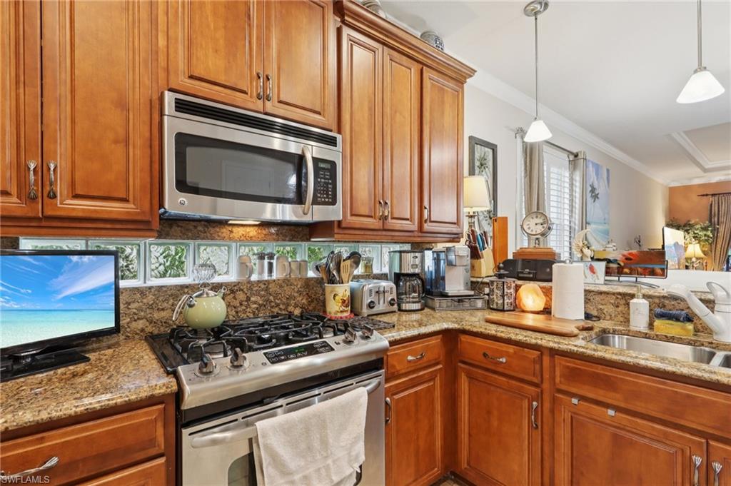 19612 Tesoro Way Estero, FL 33967 - Photo 17 of 50 a kitchen with stainless steel appliances granite countertop a stove a sink and a microwave