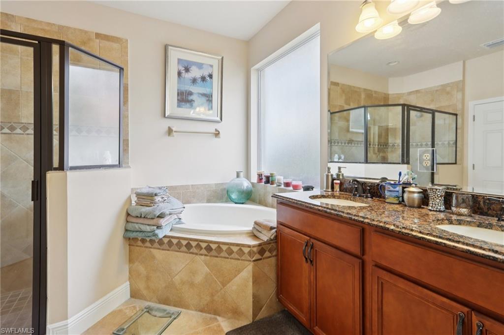 19612 Tesoro Way Estero, FL 33967 - Photo 21 of 50 a bathroom with a granite countertop sink and a mirror
