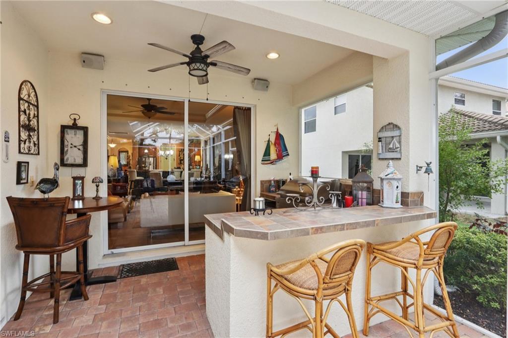 19612 Tesoro Way Estero, FL 33967 - Photo 29 of 50 a dining hall with stainless steel appliances granite countertop a stove a refrigerator a dining table and chairs with wooden floor