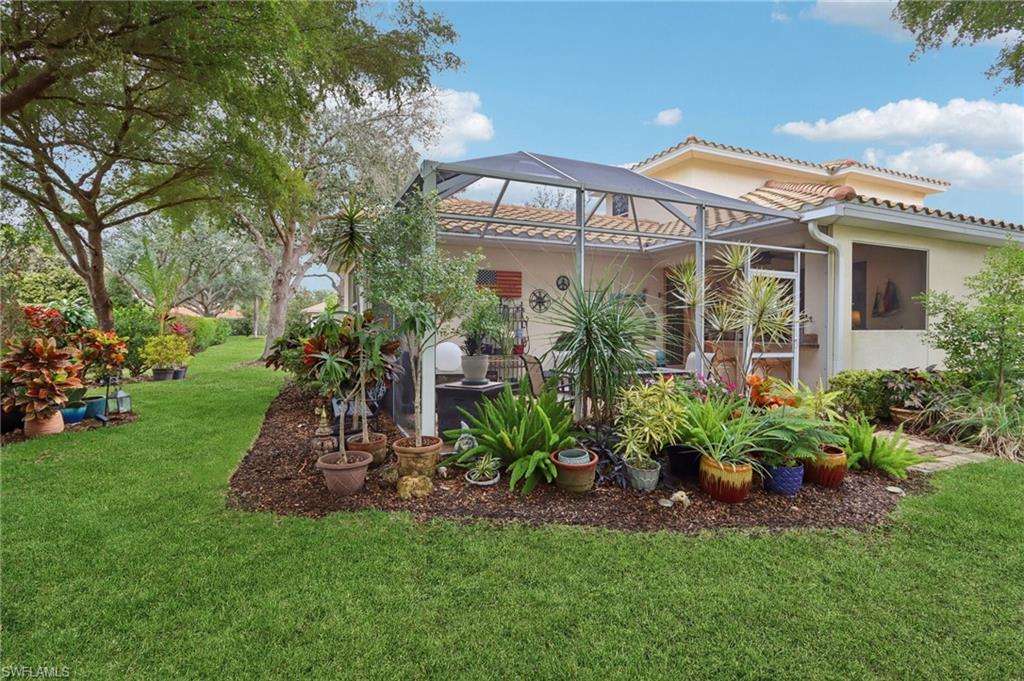 19612 Tesoro Way Estero, FL 33967 - Photo 31 of 50 a front view of a house with a garden