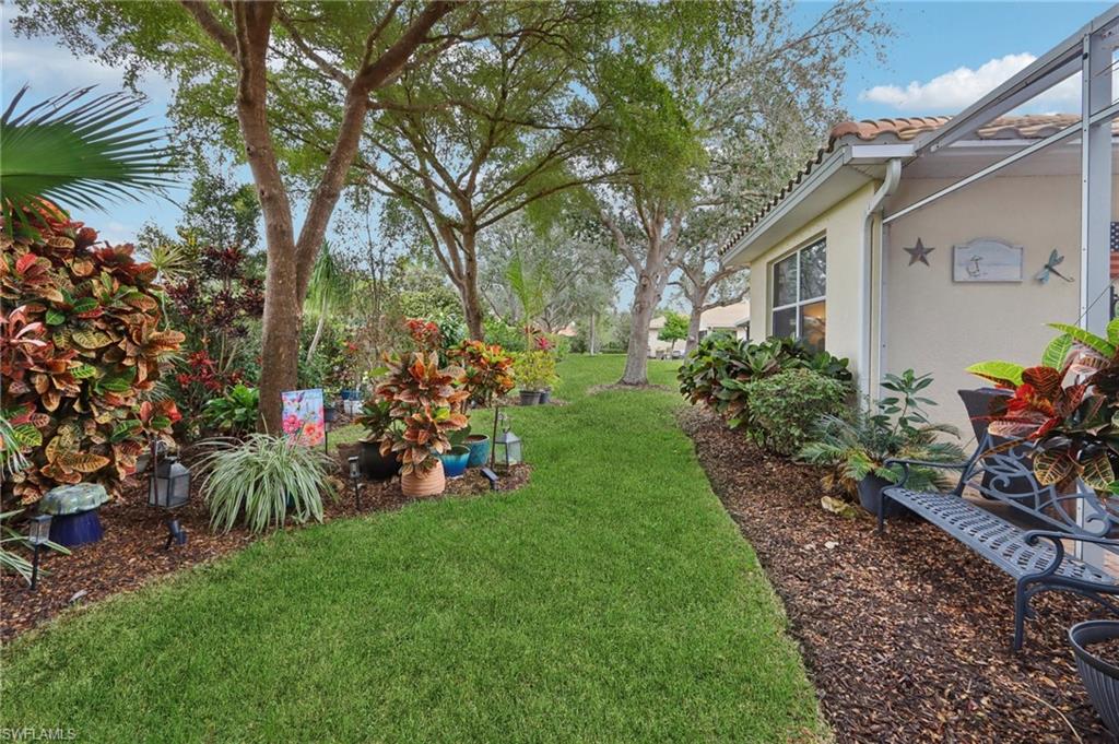 19612 Tesoro Way Estero, FL 33967 - Photo 32 of 50 a view of a house with a backyard and a tree
