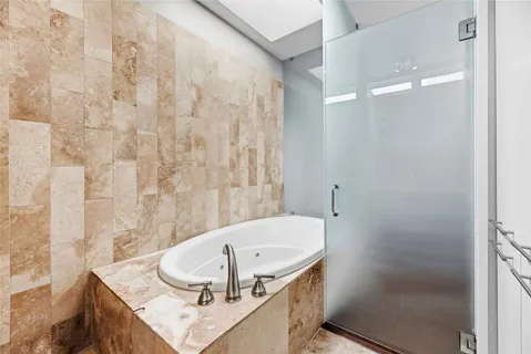 a bathroom with a double vanity sink mirror and bathtub