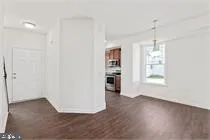 a view of a kitchen with wooden floor and a window