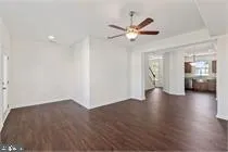 a view of a livingroom with wooden floor and a ceiling fan