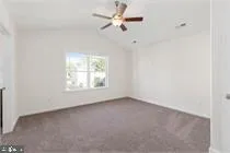 an empty room with a window and a fan