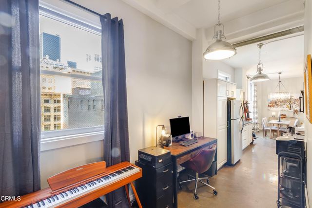 a view of a workspace with furniture and a window