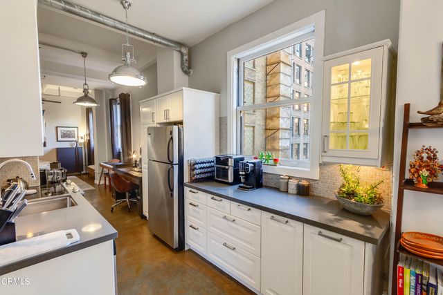 a kitchen with sink refrigerator and window