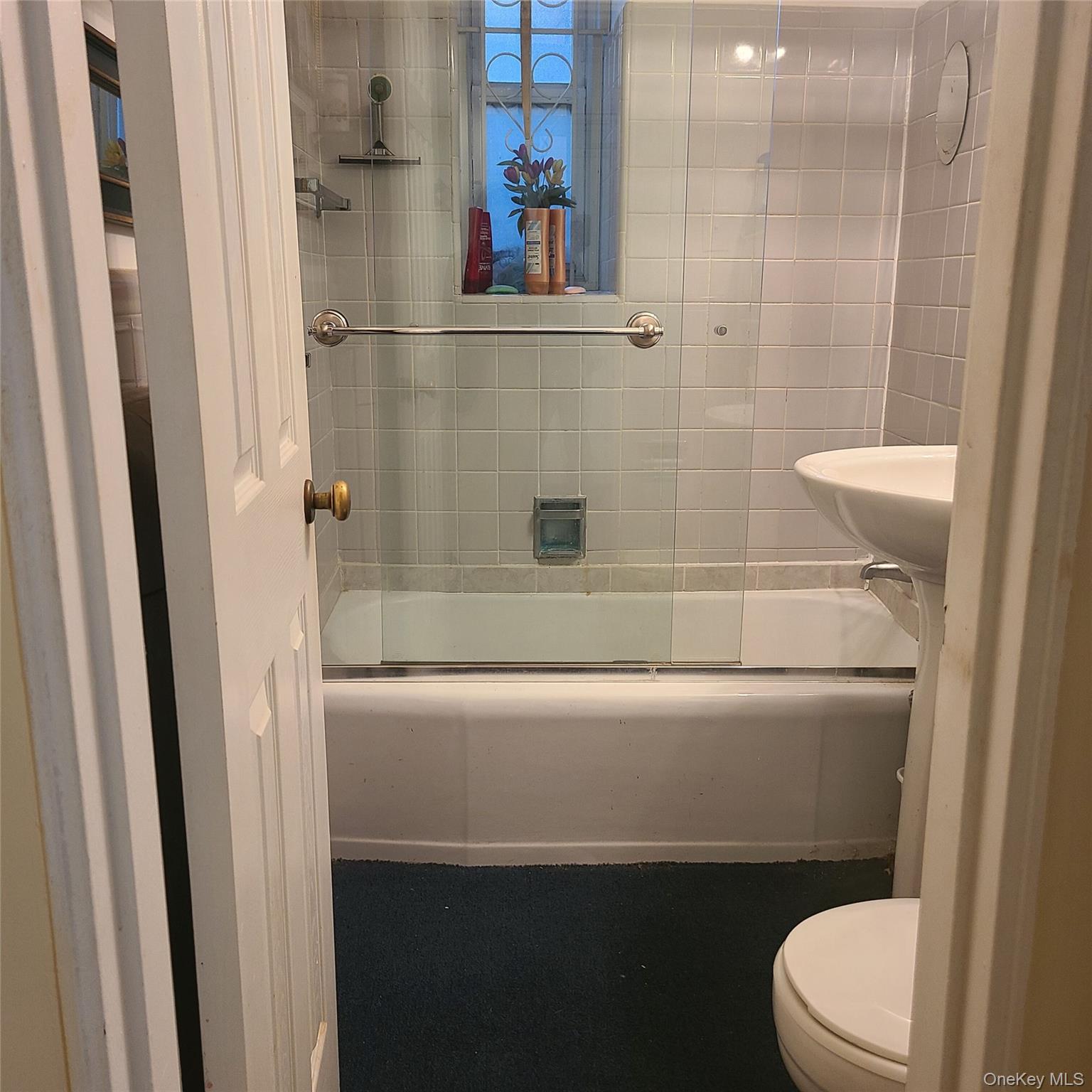 83-25 98th Street, Unit 2T Queens, NY 11421 - Photo 5 of 6 a bathroom with a sink a toilet and shower
