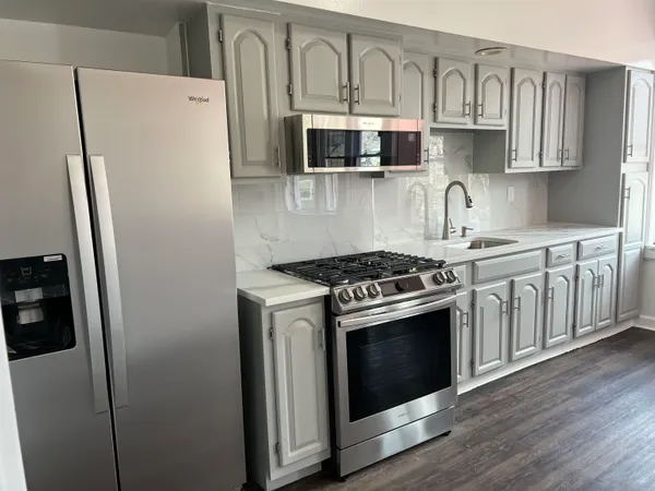 a kitchen with stainless steel appliances granite countertop a stove a refrigerator and a sink