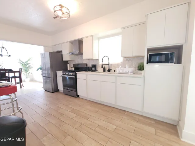 a kitchen with a sink appliances cabinets and a window