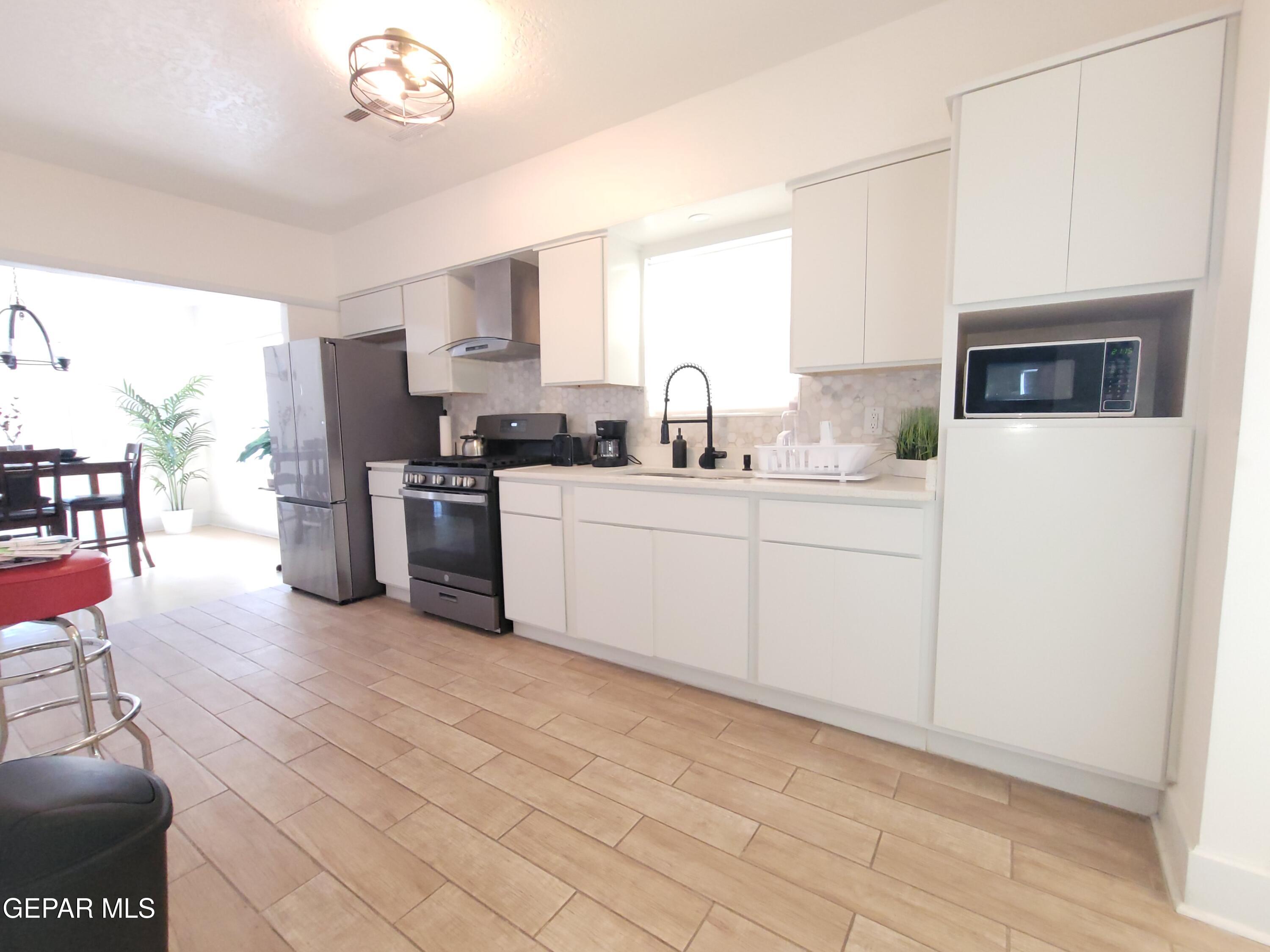 4012 Trowbridge Drive, Unit A FURNISHED El Paso, TX 79903 - Photo 12 of 53 a kitchen with stainless steel appliances a sink a stove a refrigerator cabinets and a window