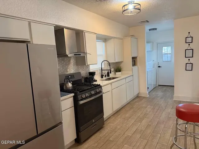 a kitchen with refrigerator and cabinets
