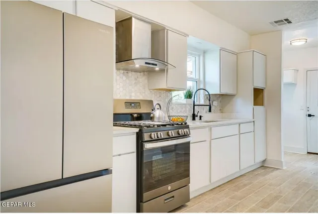 a stove top oven sitting inside of a kitchen
