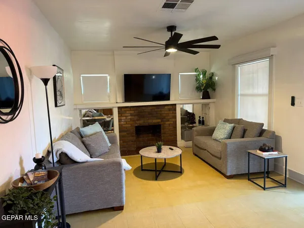 a living room with furniture a flat screen tv and a fireplace
