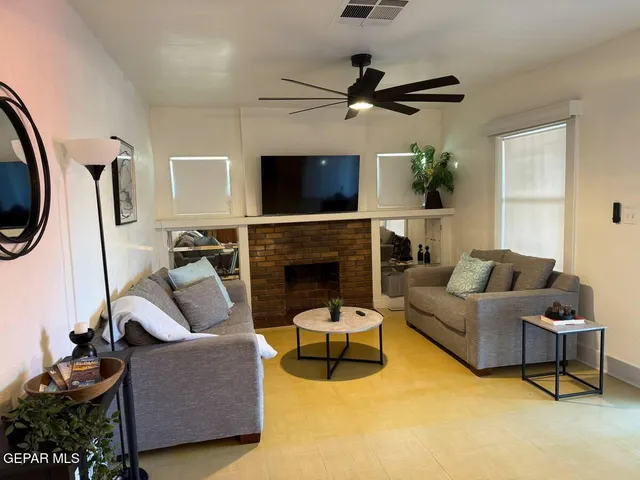 a living room with furniture a flat screen tv and a fireplace
