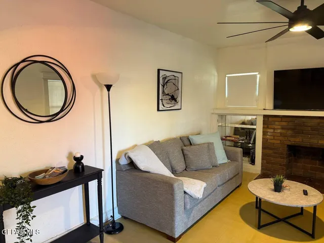 a living room with furniture a flat screen tv and a fireplace