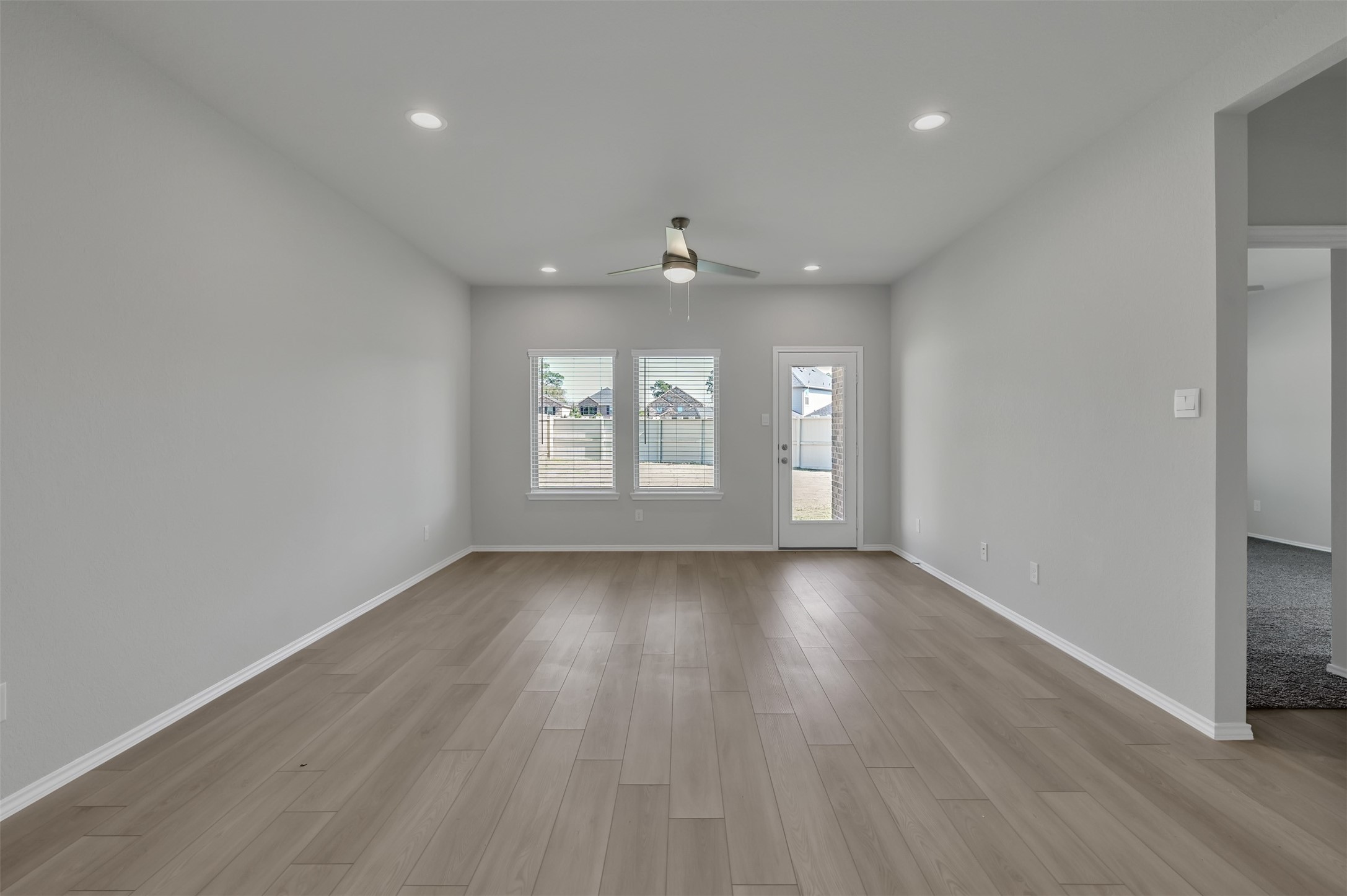 17105 Upland Bent Court Conroe, TX 77385 - Photo 14 of 40 an empty room with wooden floor and windows