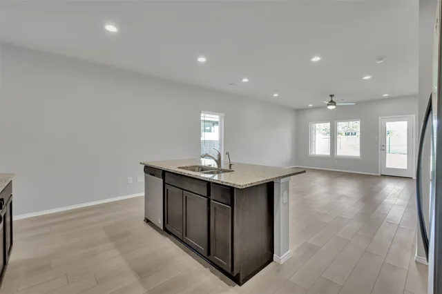 a kitchen with granite countertop wooden cabinets stainless steel appliances and sink