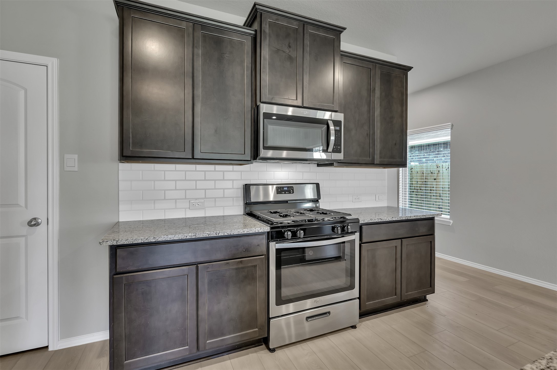 17105 Upland Bent Court Conroe, TX 77385 - Photo 10 of 40 a kitchen with granite countertop wooden cabinets stainless steel appliances and sink
