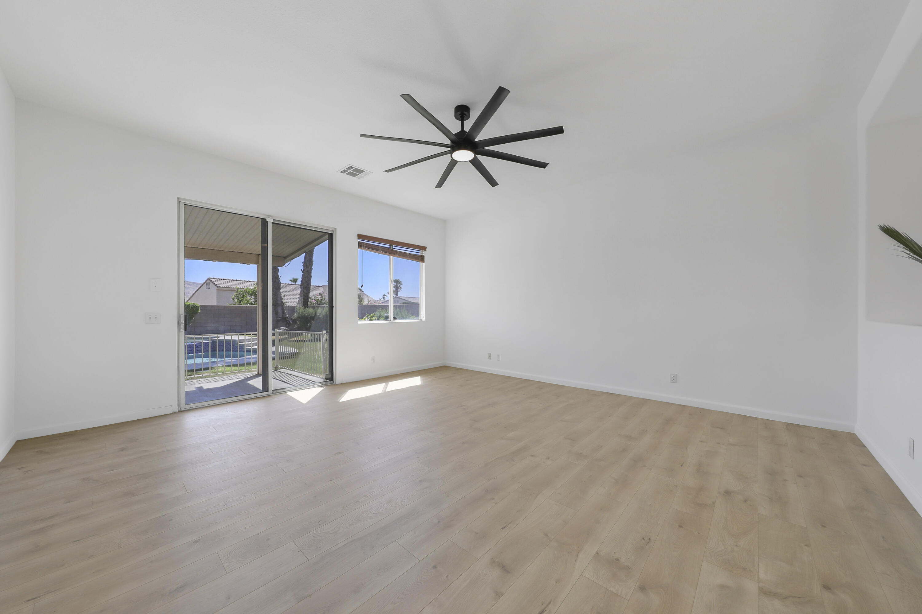 68256 Pasada Road Cathedral City, CA 92234 - Photo 10 of 35 an empty room with wooden floor fan and windows