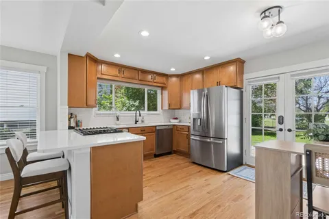 a kitchen with a refrigerator a stove top oven and a large window