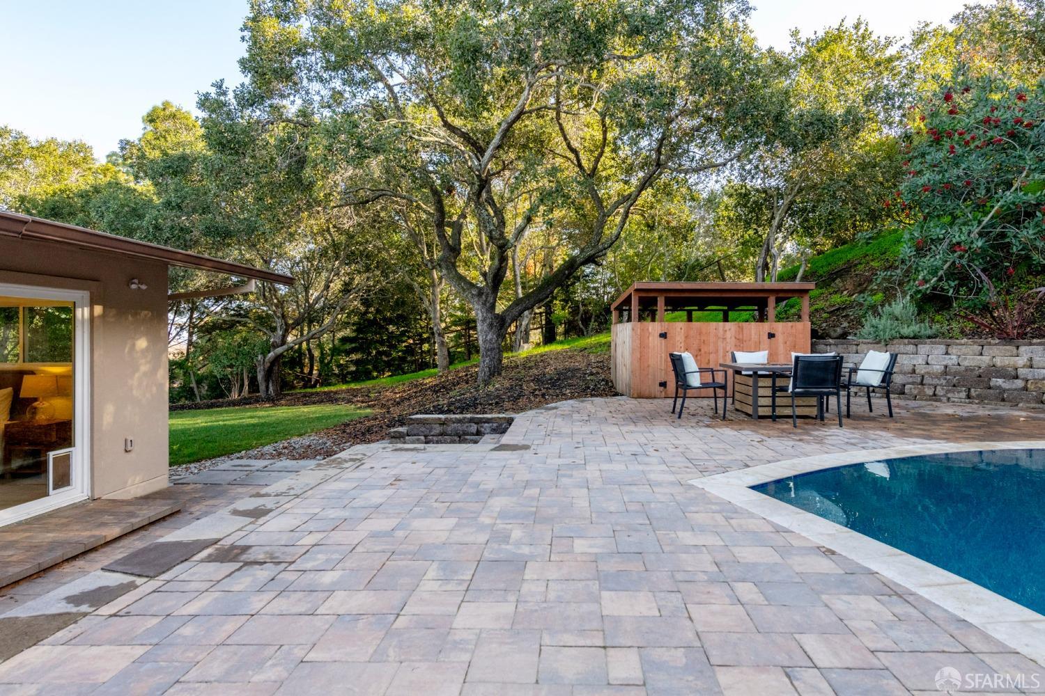 155 Brookwood Road Woodside, CA 94062 - Photo 40 of 60 a view of a patio with table and chairs under an umbrella