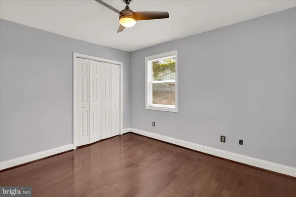 an empty room with a ceiling fan and window