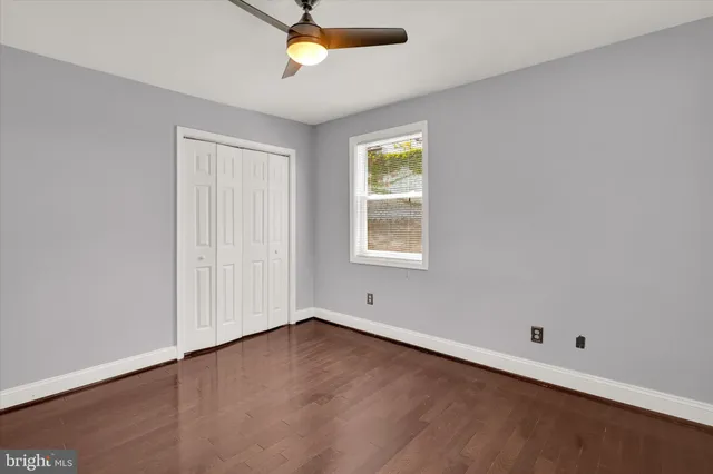 an empty room with a ceiling fan and window
