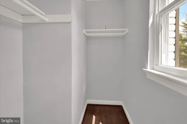 an empty room with a window and a ceiling fan