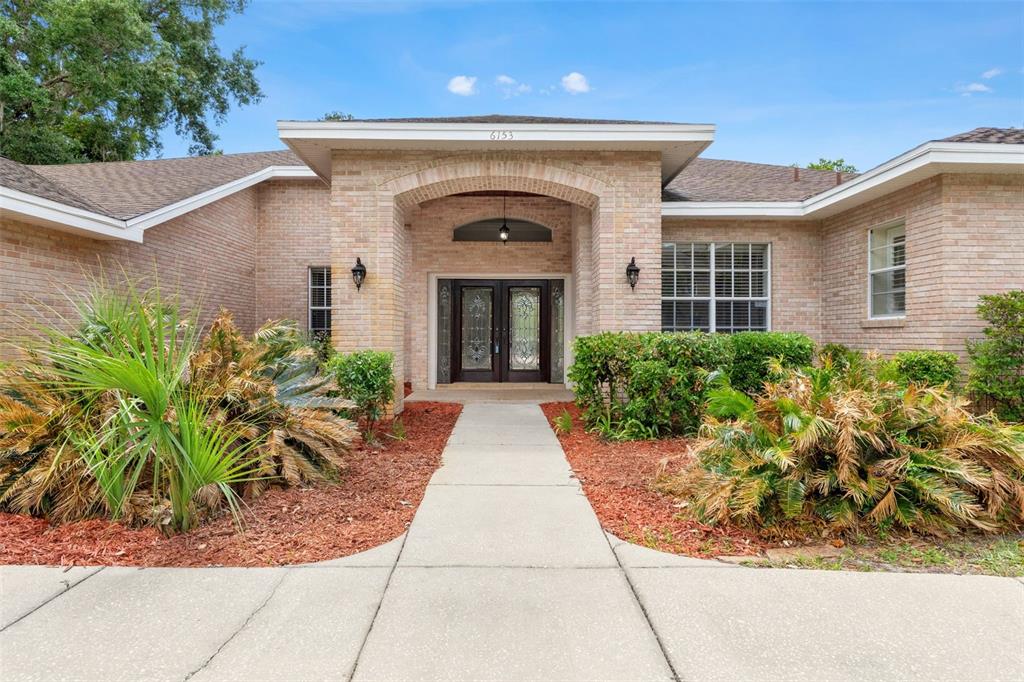 6153 New Osprey Point Weeki Wachee, FL 34607 - Photo 7 of 65 a front view of a house with garden