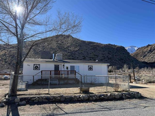 View of front of house with a mountain view and a fenced front yard