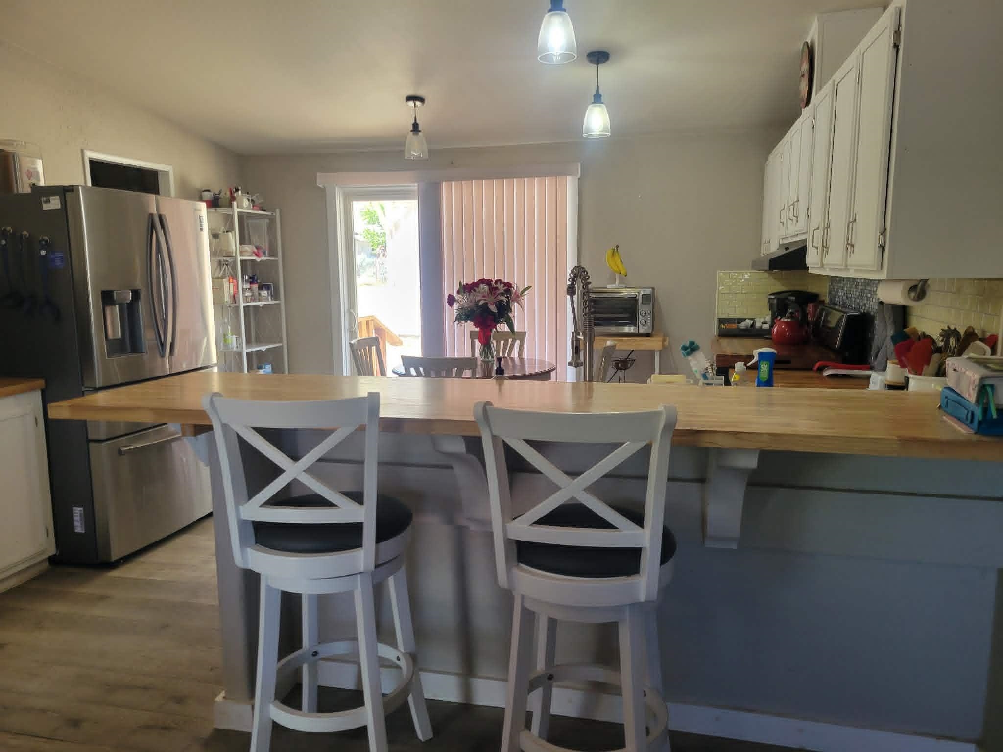 493 Mule Deer Road Coleville, CA 96107 - Photo 11 of 39 a kitchen with stainless steel appliances kitchen island granite countertop a table chairs in it and wooden floors