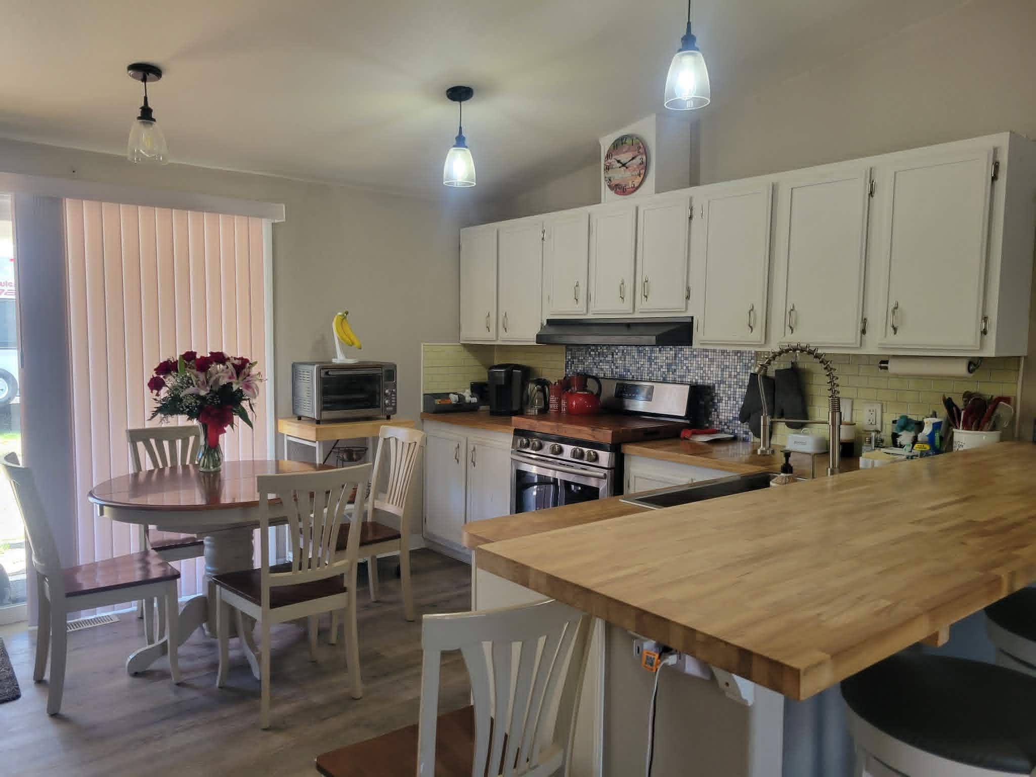 493 Mule Deer Road Coleville, CA 96107 - Photo 12 of 39 a kitchen with granite countertop a stove a sink a kitchen island with chairs and white cabinets