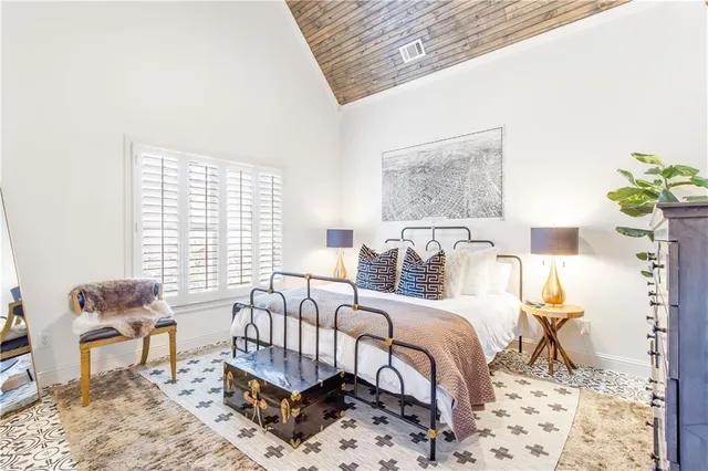 a bedroom with a large bed and a lamp with window