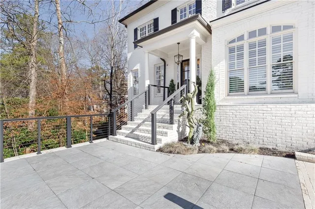 a front view of a house with a garden and trees