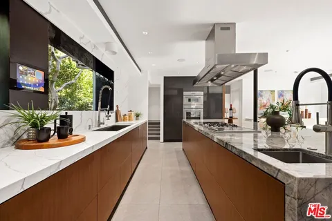 a large kitchen with kitchen island a large window in it