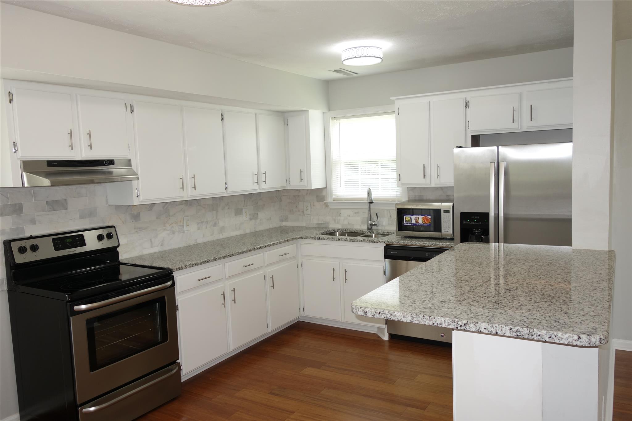 1545 Ridgemont Drive La Vergne, TN 37086 - Photo 8 of 25 a kitchen with granite countertop a stove a sink and a refrigerator