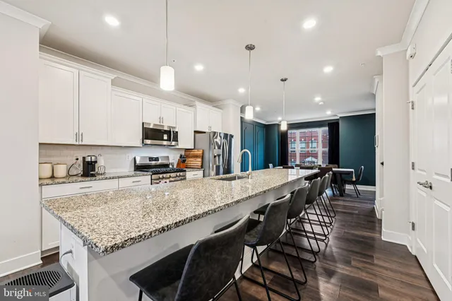 a large kitchen with granite countertop lots of counter space and wooden floor