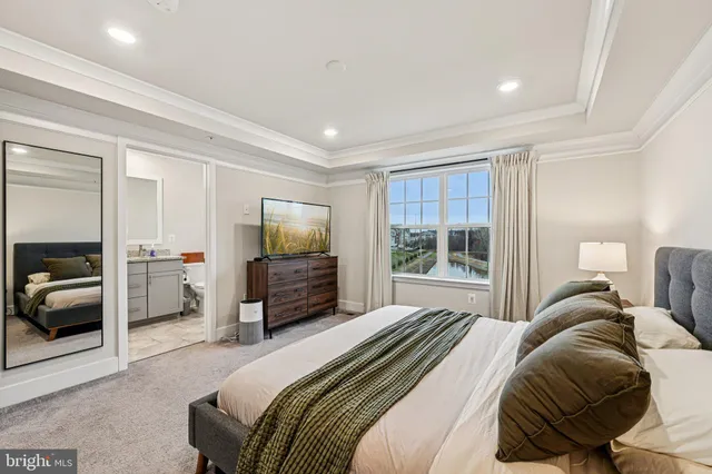 a bedroom with a large bed and a flat tv screen