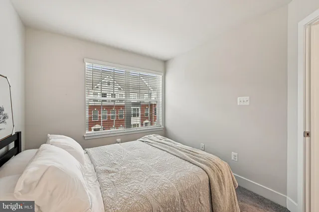 a bedroom with a bed and a large window