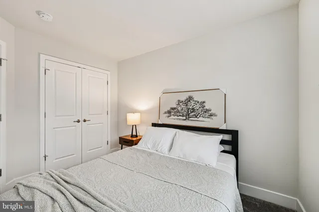 a bedroom with a bed and a painting on the wall
