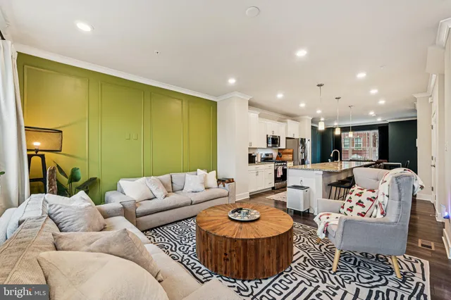 a living room with furniture kitchen view and a large window