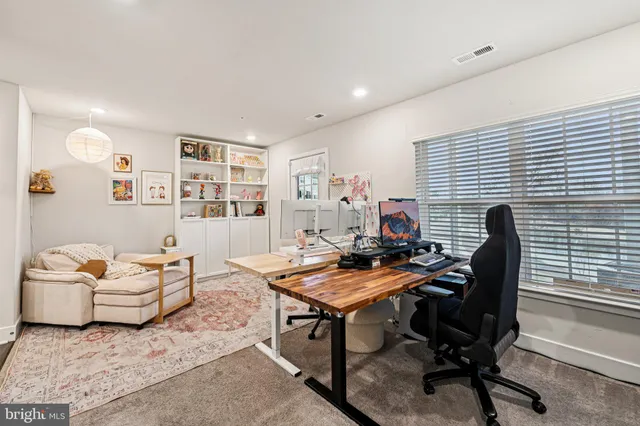 a living room with furniture and a work place area