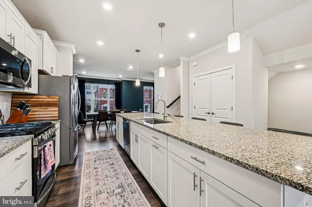 a kitchen with stainless steel appliances kitchen island granite countertop a stove a sink and a refrigerator