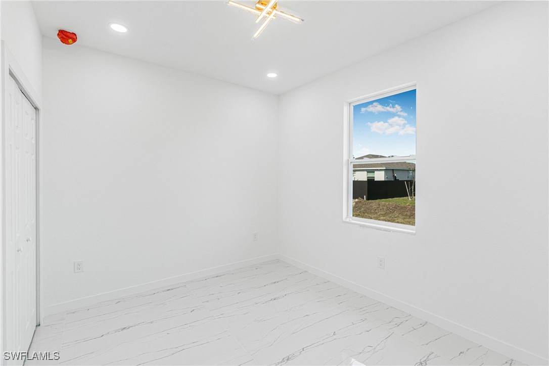 3604 26th Street Southwest Lehigh Acres, FL 33976 - Photo 23 of 38 a view of a livingroom with a projector and a window