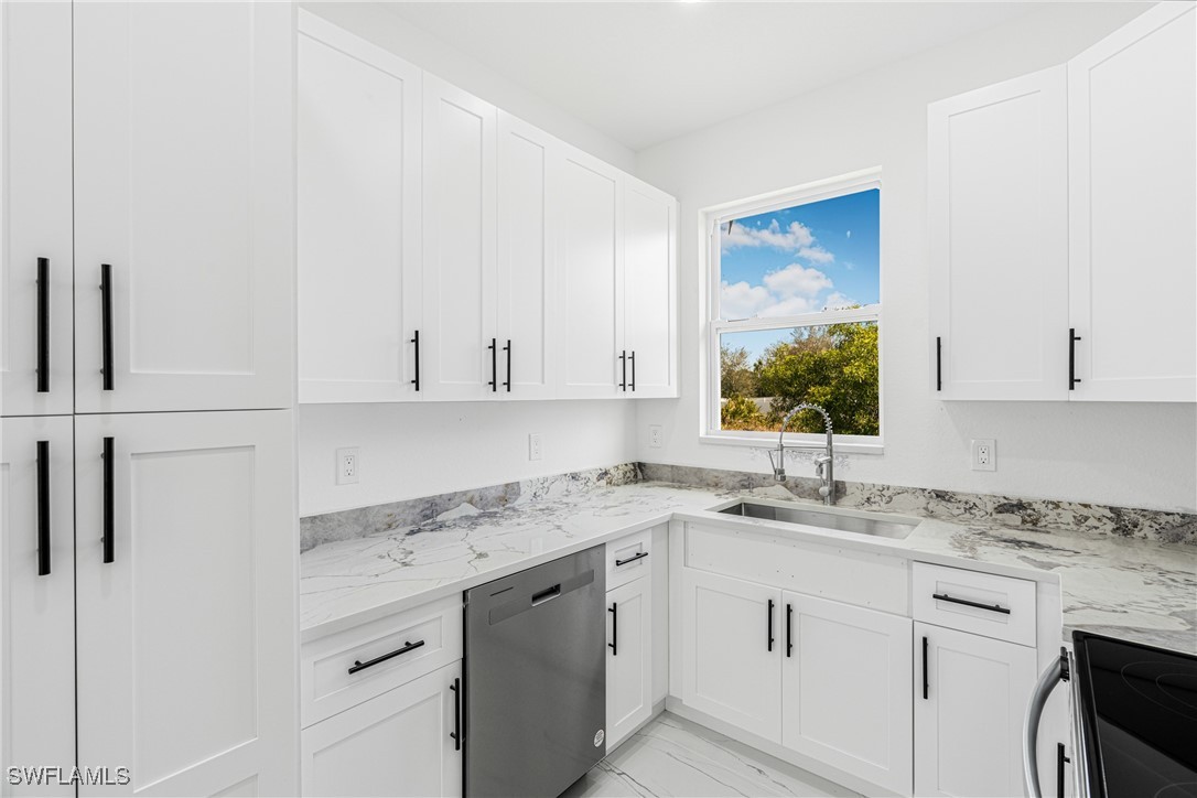 3604 26th Street Southwest Lehigh Acres, FL 33976 - Photo 9 of 38 a kitchen with granite countertop white cabinets and white appliances