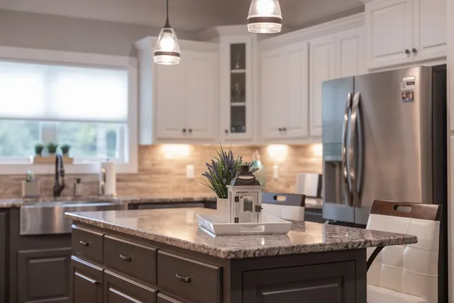 a kitchen with stainless steel appliances granite countertop a stove refrigerator and cabinets